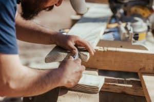 Un homme travaillant sur un morceau de bois Un homme travaillant sur un morceau de bois photo